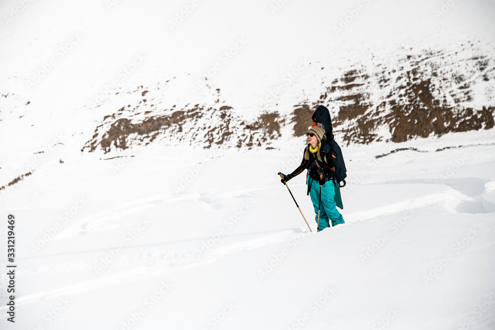 woman snowboarder on the background of snow-capped mountains and cloudy sky.