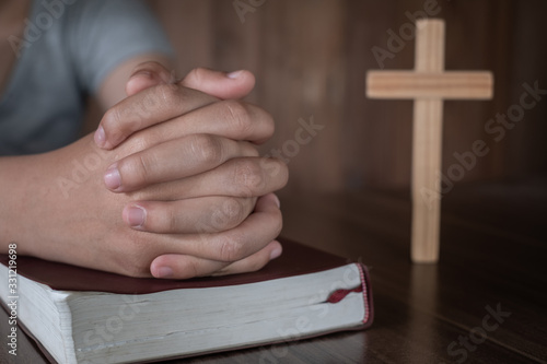 A close-up shot of a woman with a cross and praying Pray or pray to God Concepts of religion, beliefs and people Begging for forgiveness and believing in goodness.