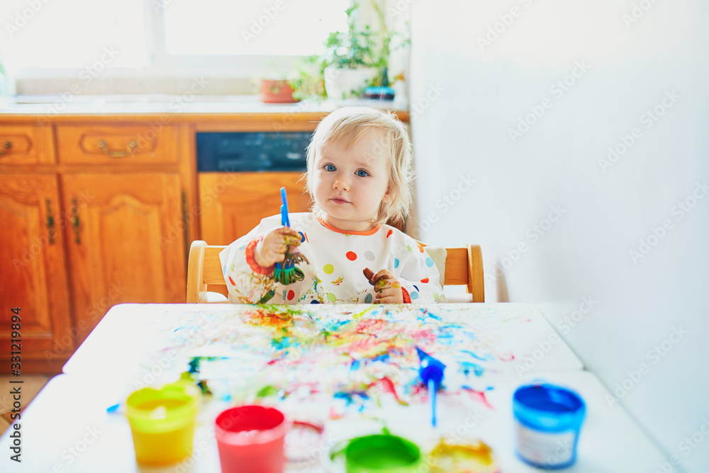Adorable little girl painting with fingers Adorable little girl painting with fingers
