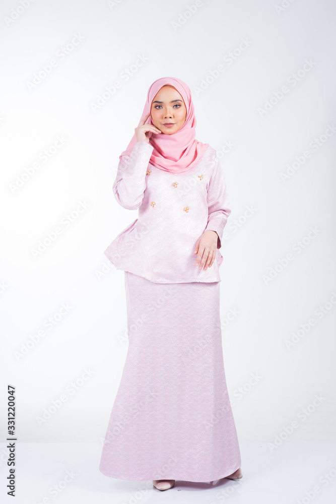 Full length portrait of a beautiful female model wearing traditional dress and hijab, a lifestyle apparel for Muslim women isolated on white background. Idul Fitri and hijab fashion concept. Full length portrait of a beautiful female model wearing traditional dress and hijab, a lifestyle apparel for Muslim women isolated on white background. Idul Fitri and hijab fashion concept.