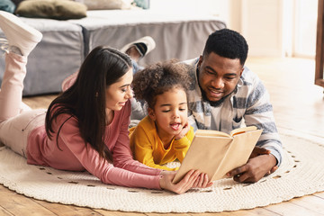 International family reading book on the floor