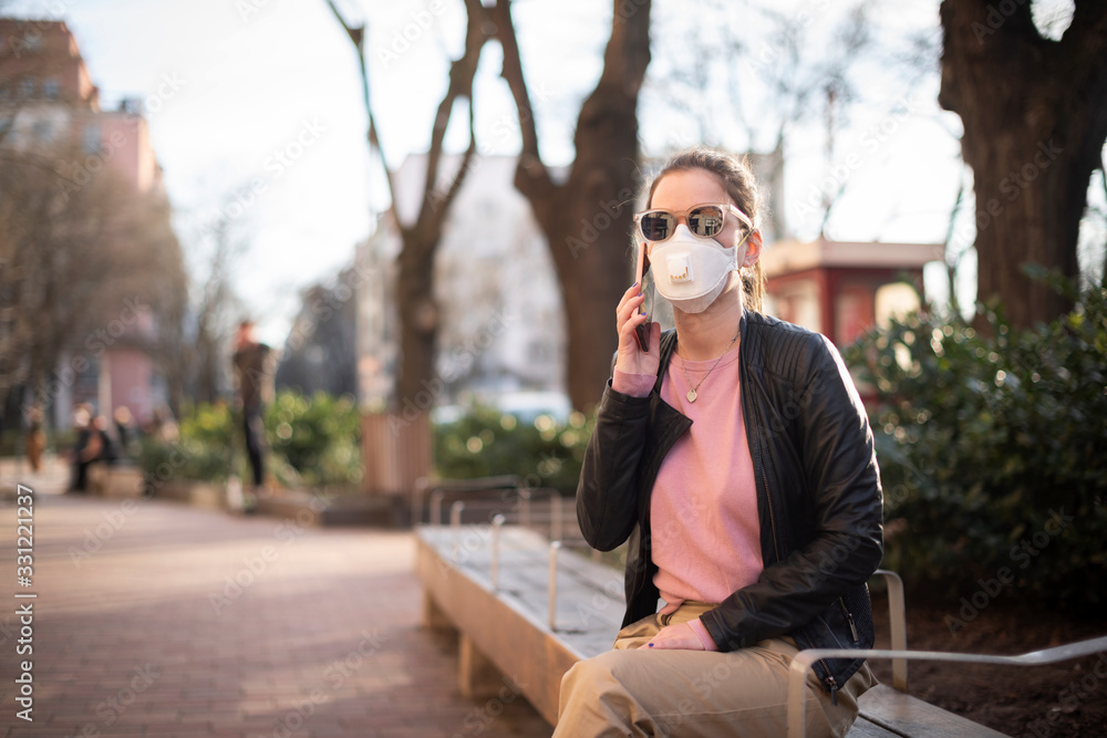 Young woman wearing a respirator mask in the city during the coronavirus outbreak Young woman wearing a respirator mask in the city during the coronavirus outbreak