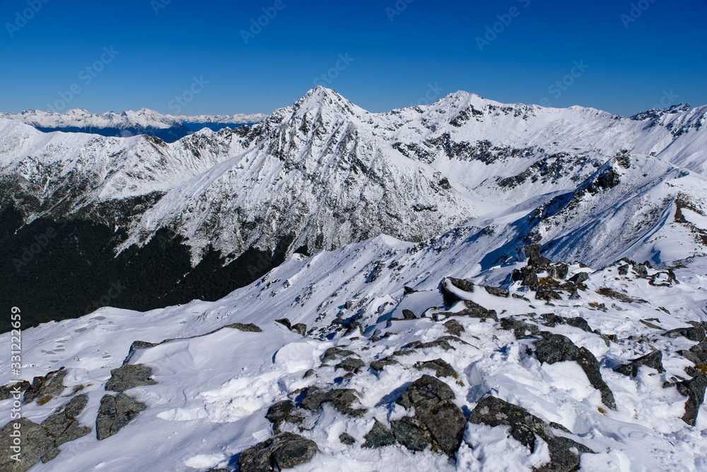 Walking at Kepler Track in Fiordland National Park in winter with snow mountains, South Island, New Zealand