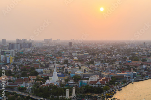 White Prayoon Pagoda, Memorial Bridge, and Phra Pok Klao Bridge with buildings and curve of Chao Phraya River at sunset. Urban city, Downtown Bangkok, Thailand. photo