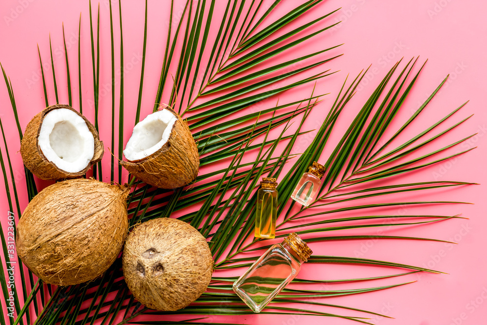 Coconut background with oil on pink background top-down Coconut background with oil on pink background top-down