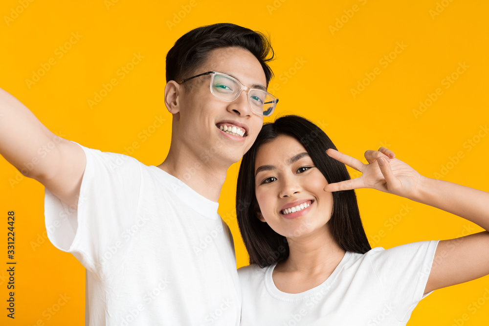 Beautiful asian couple in love smiling while taking selfie Beautiful asian couple in love smiling while taking selfie