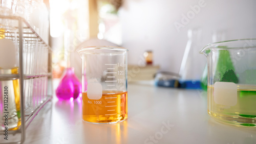 Photo of Scientific equipment and chemistry glassware putting together on white working desk over laboratory white wall as background.