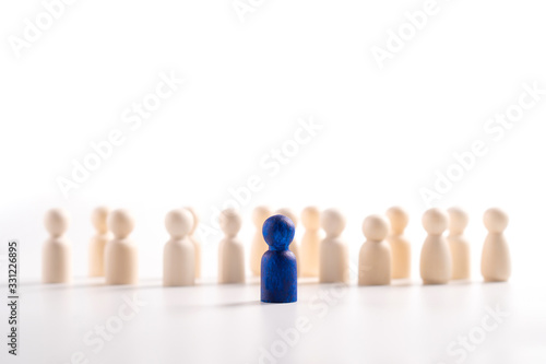 Wooden figure standing in front of the team to show influence and empowerment. Concept of business leadership for leader team, successful competition winner and Leader with influence