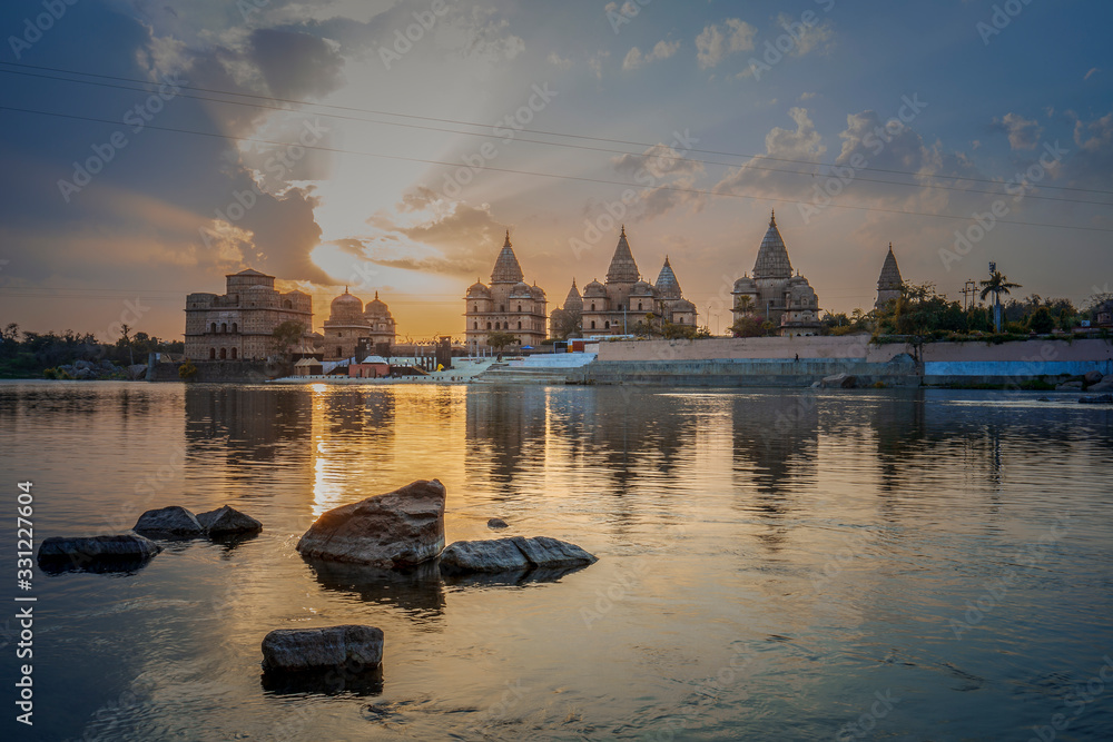 Obraz premium Sunset view of chhatri or canopies at Orchha from across the betwa river in Orchha Madhya Pradesh India.
