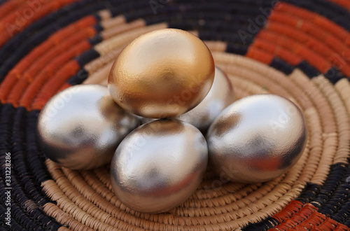 Eggs of natural chicken colored in gold & silver are Concept Of Financial Growth laying traditional handcraft background