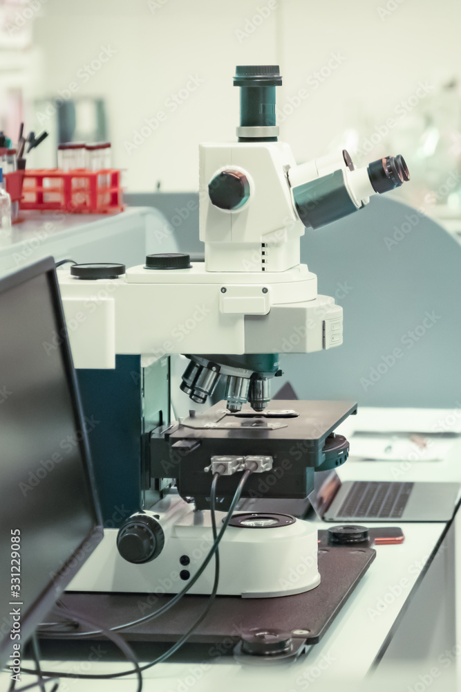 Microscope with metal lens at laboratory for developing vaccines against coronavirus