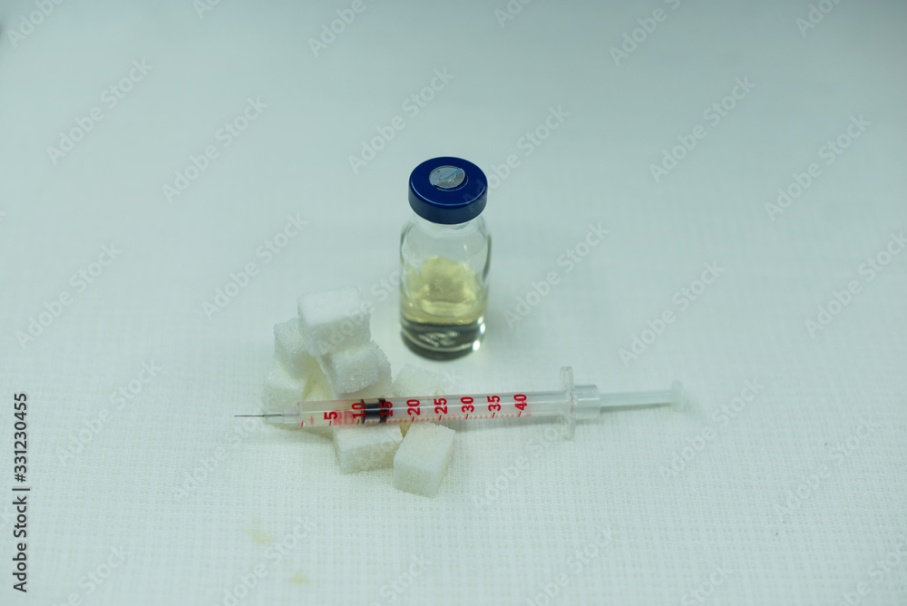 Syringes for insulin on the background of sugar cubes. Diabetes Vaccine Syringes for insulin on the background of sugar cubes. Diabetes Vaccine