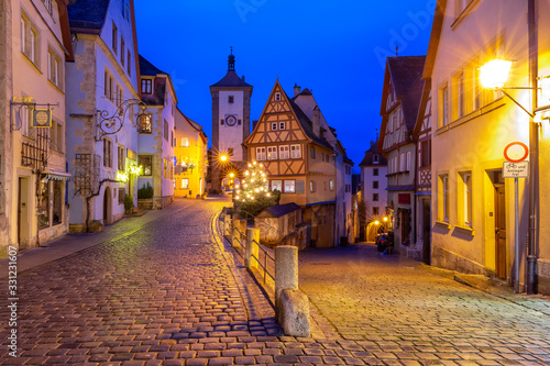 Decorated and illuminated Christmas street with gate and tower Plonlein in medieval Old Town of Rothenburg ob der Tauber  Bavaria  southern Germany