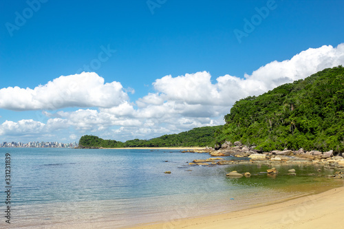 Mar azul esverdeado e rochas  na paisagem da praia do Plaza, ao fundo prédios de Itapema photo