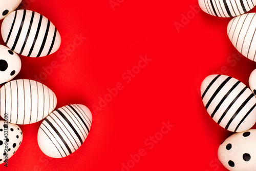 Different graphic hand-painted eggs on bright red background. Easter concept. Place for text.