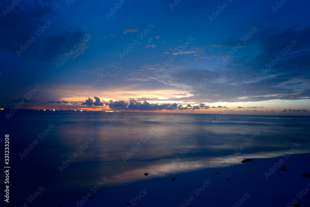 Tropical colorido atardecer espectacular con cielo nublado. Brillante resplandor crepuscular en la playa en Isla Mujeres, México