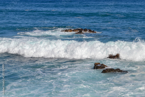 Canary islands in the Atlantic Ocean. Waves on the black rocky coast volcanic Tenerife Island.