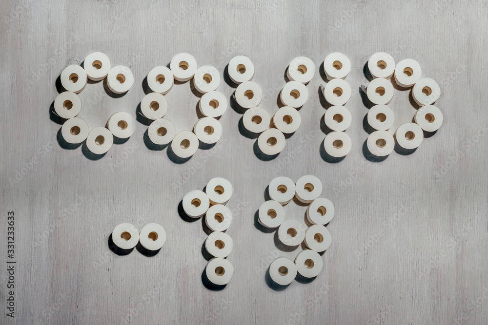 Title Covid-19 made with rolls of toilet paper on white wooden background. Concept of crisis, coronavirus quarantine, pandemic Title Covid-19 made with rolls of toilet paper on white wooden background. Concept of crisis, coronavirus quarantine, pandemic