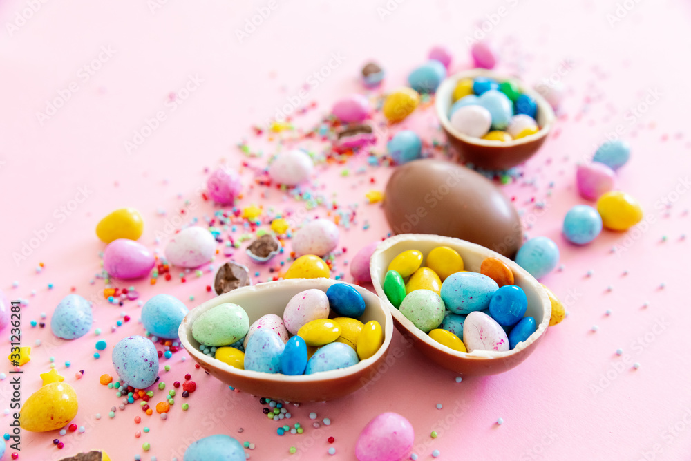 Chocolate Easter eggs with multi-colored candy decorations. Copy space