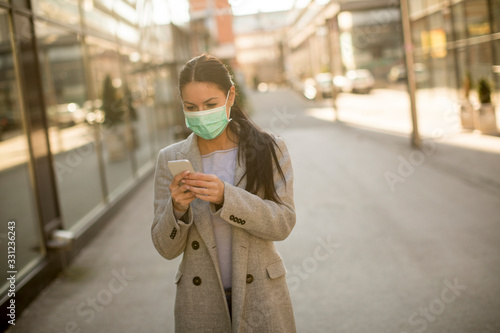 Pretty young woman with protective facial mask on the street