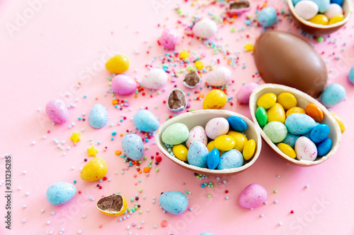 Chocolate Easter eggs with multi-colored candy decorations. Copy space © smishura