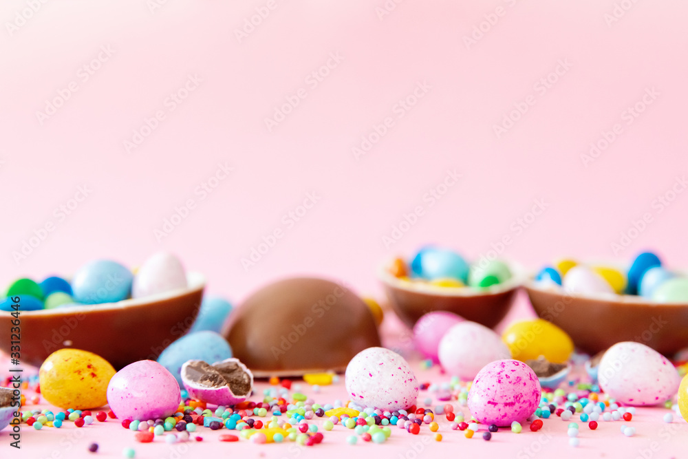 Chocolate Easter eggs with multi-colored candy decorations. Copy space