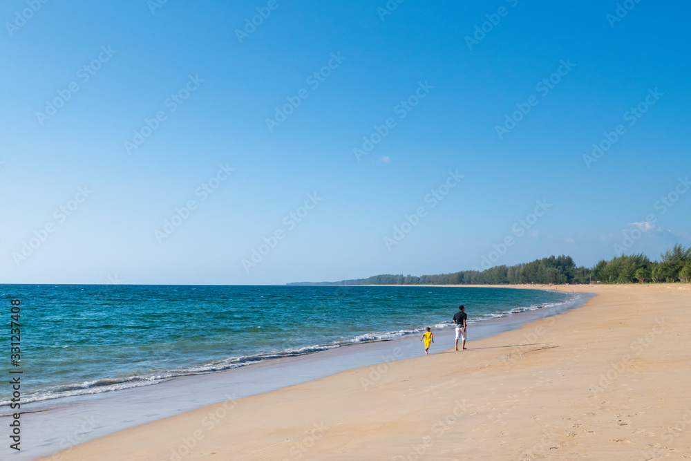 father and son walking in happy moment on Mai Khao beach, Talang, Phuket in Sunset time