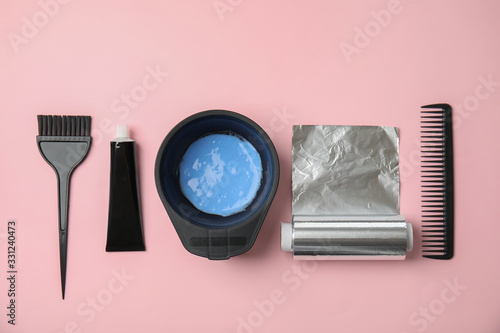 Professional tools for hair dyeing on pink background, flat lay