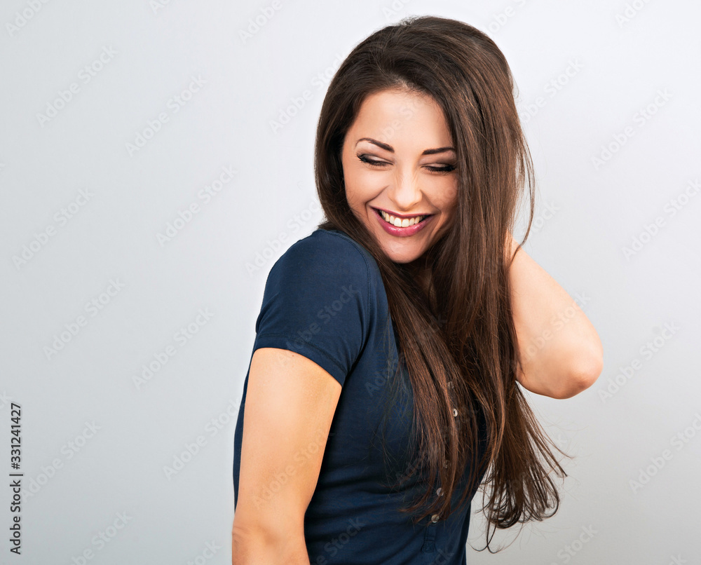 Beautiful positive laughing woman in blue casual shirt with long hair on blue background. Closeup Beautiful positive laughing woman in blue casual shirt with long hair on blue background. Closeup