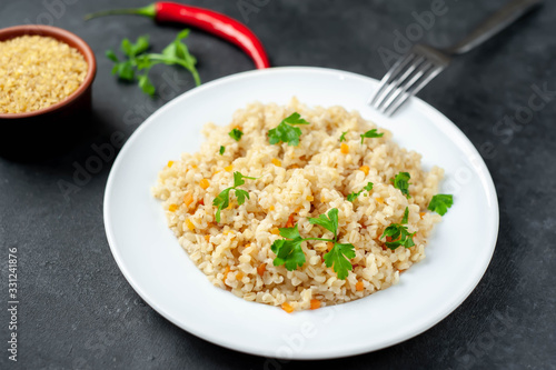 Bulgur with vegetables on a stone background. Healthy eating