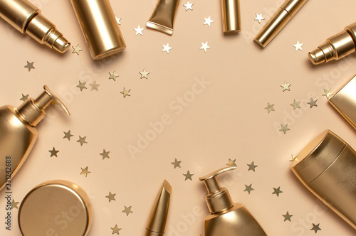 Cosmetic mock up gold bottles. Cosmetics Branding Concept. Cosmetic containers on beige background with gold stars confetti. Flat lay top view copy space. Cosmetic products, beauty background