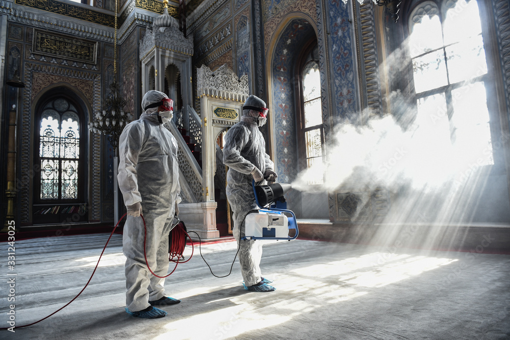 A member of Istanbul's Municipality disinfects the mosque in Istanbul to prevent the spread of the COVID-19, the novel coronavirus - obrazy, fototapety, plakaty 