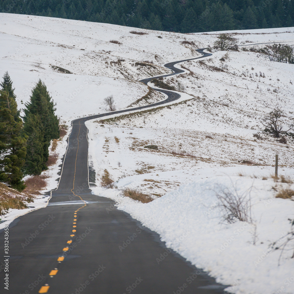 Road Cuts Through Snowy Hill Side