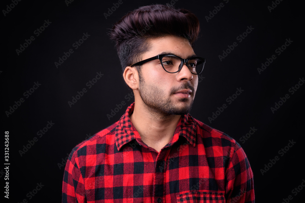 Young handsome Indian man against black background Young handsome Indian man against black background
