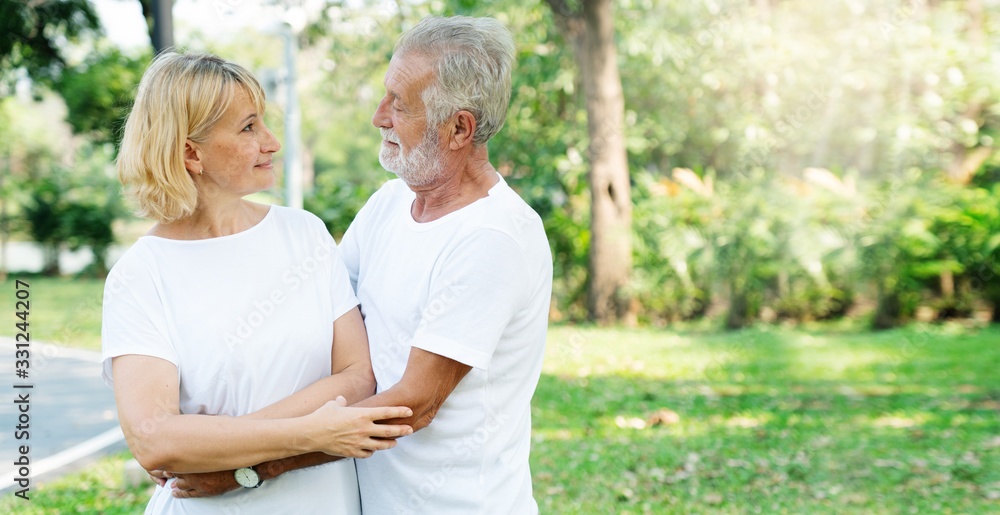 Fototapeta premium Senior Caucasian couple hugging in park. Family with a happy smile feels relaxed with nature in the morning.