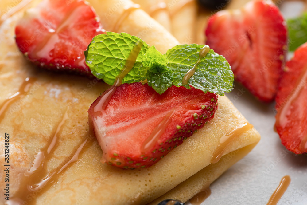 close up view of tasty crepes with strawberries and mint close up view of tasty crepes with strawberries and mint