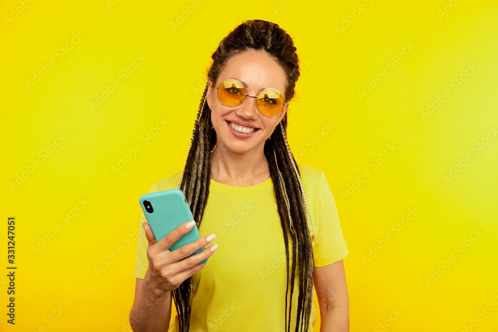 Happy smiling woman with bright phone in the yellow studio Happy smiling woman with bright phone in the yellow studio