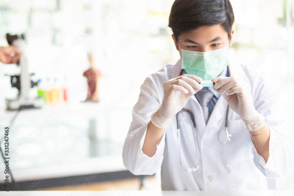 The doctor is testing a sample of biological tubes contaminated by Corona-virus Covid 19 and searching for a vaccine or Syrup against the virus. In the laboratory and film samples of infected lung The doctor is testing a sample of biological tubes contaminated by Corona-virus Covid 19 and searching for a vaccine or Syrup against the virus. In the laboratory and film samples of infected lung
