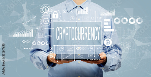 Cryptocurrency theme with young man holding a tablet computer photo