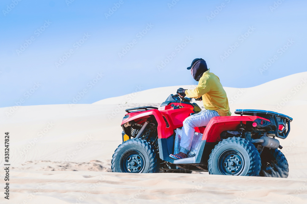Tourist enjoy riding the quad bike or powerful fast off-road four-wheel drive ATVs at white sand dunes in Mui Ne, Vietnam. Tourist enjoy riding the quad bike or powerful fast off-road four-wheel drive ATVs at white sand dunes in Mui Ne, Vietnam.