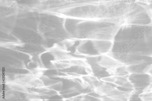 Water texture overlay effect for photo and mockups. Organic drop diagonal shadow and light caustic effect on a white wall.