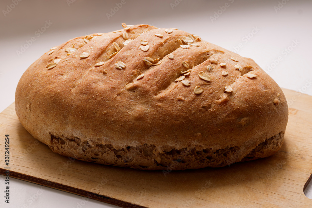 Freshly baked homemade buckwheat flour and whole grain corn bread. Bread sprinkled with oat flakes on a white background. Healthy gluten free food. Freshly baked homemade buckwheat flour and whole grain corn bread. Bread sprinkled with oat flakes on a white background. Healthy gluten free food.