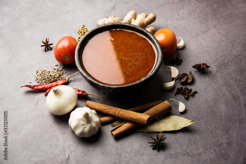 North Indian basic spicy Curry or masala for vegetables or chicken or mutton recipe shown with ingredients, served in a bowl. selective focus homemade, restaurant, hot, oil, dark, red, indian, india, 