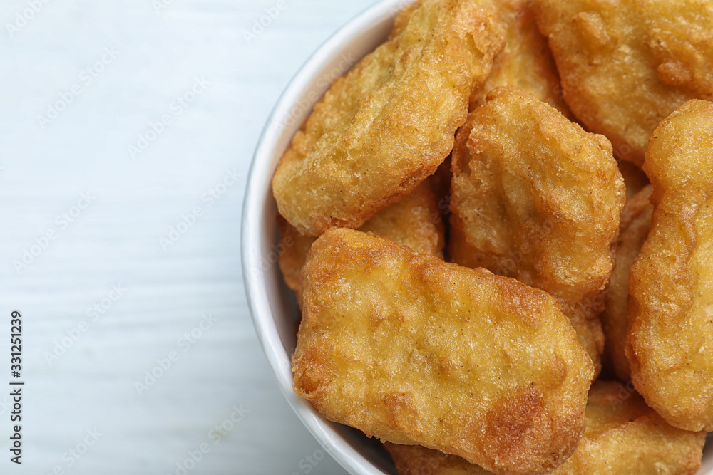 Bucket with tasty chicken nuggets on white wooden table, top view Bucket with tasty chicken nuggets on white wooden table, top view