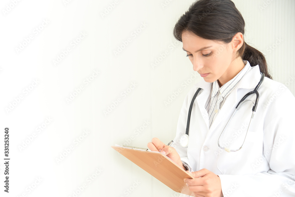 Female doctor filling out medical document. Young woman physician with stethoscope prescribing treatment to patient. Female doctor with pen writing recipe on clipboard in hospital. Female doctor filling out medical document. Young woman physician with stethoscope prescribing treatment to patient. Female doctor with pen writing recipe on clipboard in hospital.