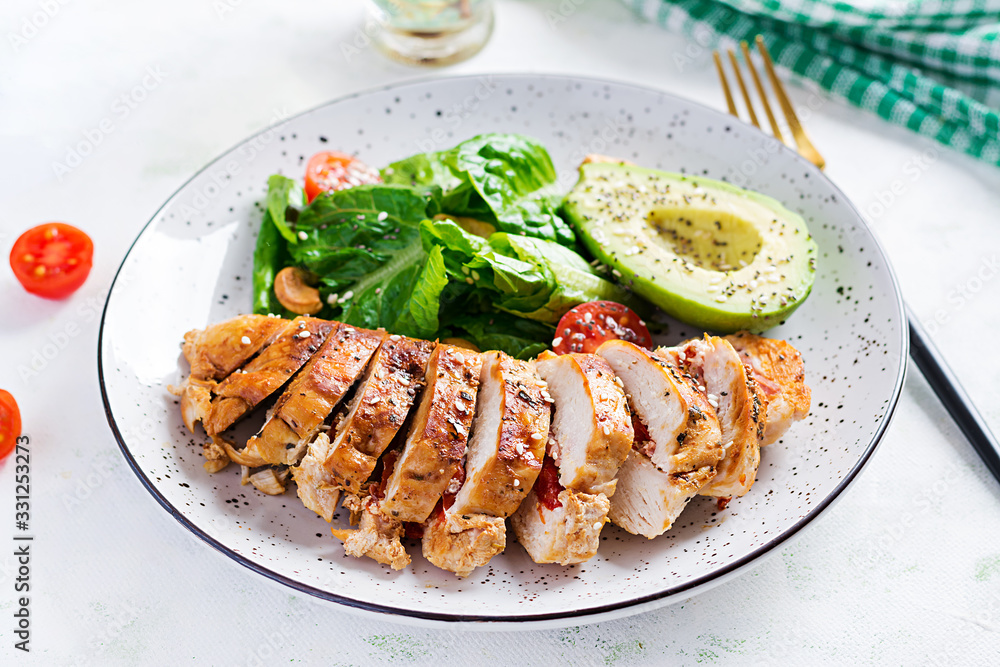Trendy salad. Chicken grilled fillet with salad fresh tomatoes and avocado. Healthy food, ketogenic diet, diet lunch concept. Keto/Paleo diet menu. Trendy salad. Chicken grilled fillet with salad fresh tomatoes and avocado. Healthy food, ketogenic diet, diet lunch concept. Keto/Paleo diet menu.