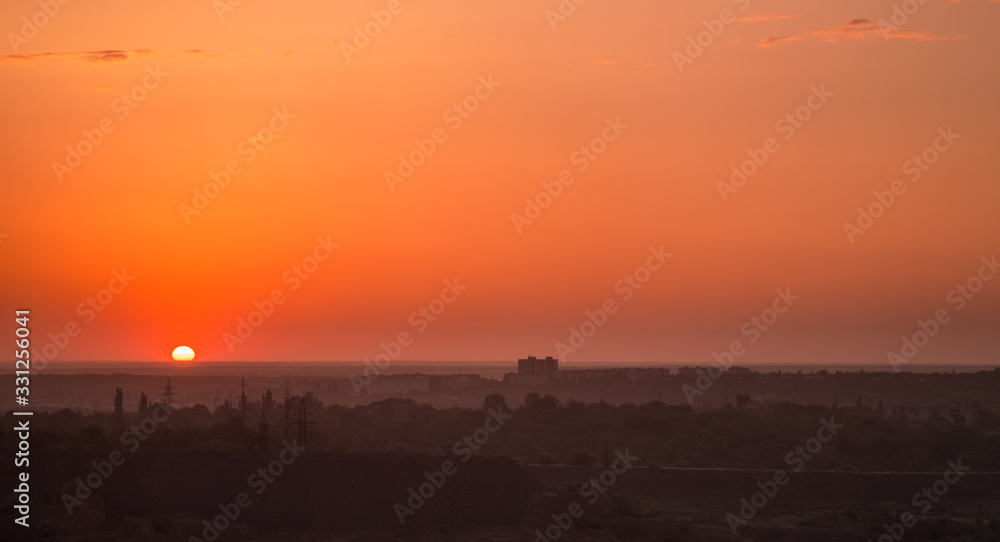 Orange sunset over the city silhouette