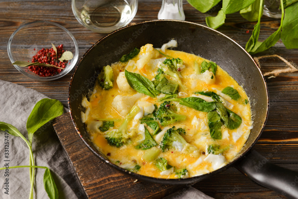 fried eggs 4 eggs with spinach and broccoli in a pan fried eggs 4 eggs with spinach and broccoli in a pan