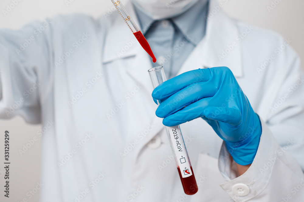 Coronavirus Covid 19 infected blood sample in sample tube in hand of scientist doctor biohazard protection clothing in coronavirus covid 19 research laboratory Coronavirus Covid 19 infected blood sample in sample tube in hand of scientist doctor biohazard protection clothing in coronavirus covid 19 research laboratory