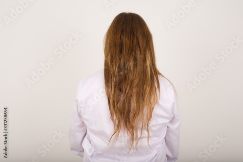 The back side view of a doctor woman wearing medical uniform.